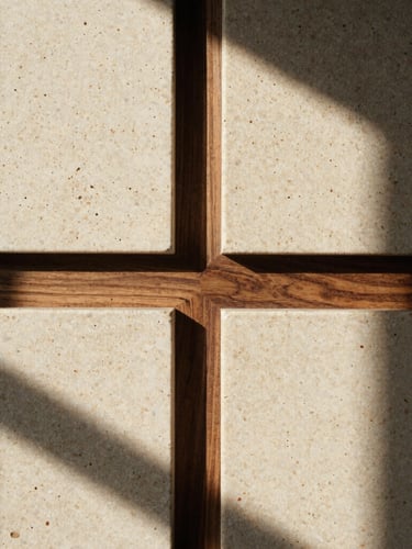 Close-up of raw, porous travertine stone texture meeting dark walnut timber joints, dramatic afternoon sun casting deep shadows, warm editorial photography, medium format film