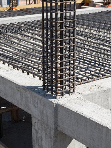 Close-up of a modern construction site in Turkey, showing high-grade structural steel rebar grid and freshly poured C35 concrete under bright daylight, architectural framing, sharp details