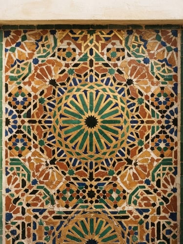 Gros plan sur un panneau de zellij traditionnel marocain, motifs géométriques complexes, couleurs terreuses et or, lumière naturelle douce, fond crème.