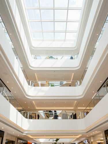 Symmetrical architectural wide-angle photo of a modern high-end retail mall atrium in Kuala Lumpur, bright natural daylight, clean lines, sharp details