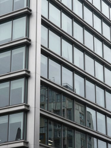 Close-up of architectural elements of a modern corporate building in Bogotá, steel and glass, cool tones, clean lines, professional corporate photography