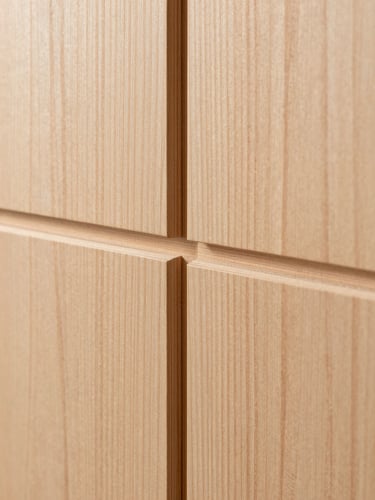 Extreme close-up of grain-matched vertical grain Douglas fir panels, showcasing raw wood texture and precise architectural joinery, soft natural side-lighting.