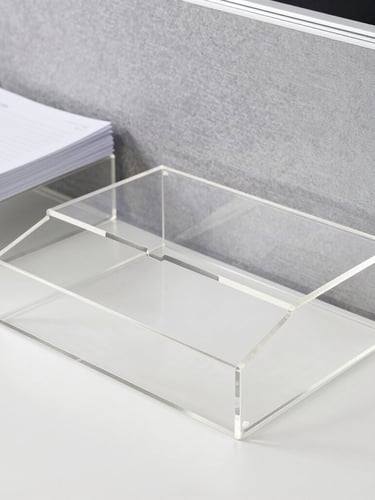 Clean eye-level environmental shot of a modern organized corporate desk with clear acrylic document holders and desk organizers, bright office light