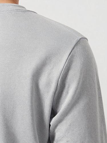 Close-up tactile detail of conscious water-resistant canvas fabric, bright soft daylight, light gray backdrop, 50mm