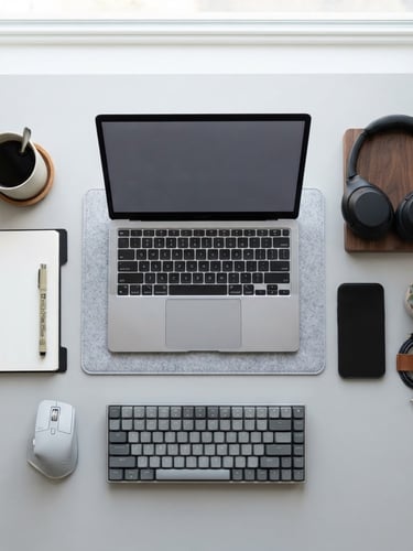 Overhead flatlay of organized workspace accessories, minimalist light gray backdrop, bright soft daylight, sharp focus, 50mm
