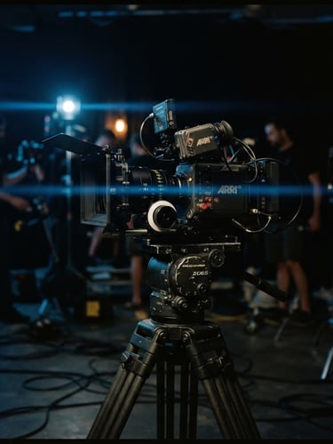 On-set cinema camera rig on a heavy tripod, dramatic low-key lighting with moody blue practical lights, anamorphic lens flare, 35mm film photography