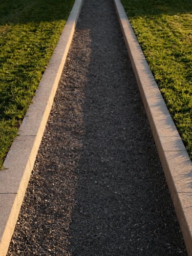 A minimalist, structured garden path in Toulouse, clean stone borders, perfectly edged lawn meeting a dark gravel path, warm golden hour light.