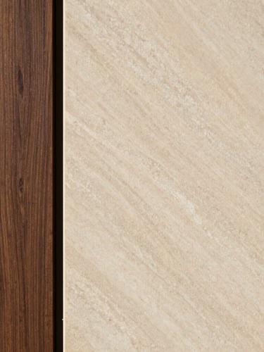 Macro detail shot of a high-end material pairing, showing a slab of honed warm travertine meeting a custom deep espresso oak panel, soft natural side lighting, architectural interior photography.