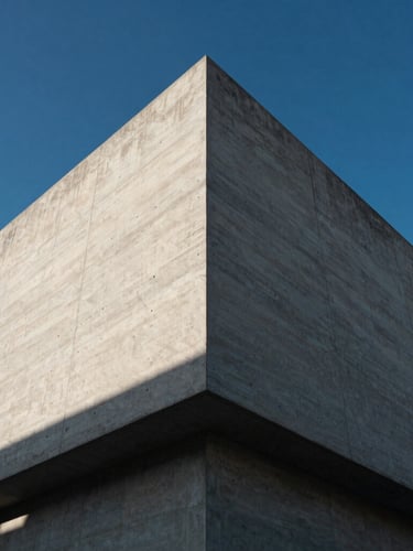 Low-angle heroic shot of a modern architectural concrete facade under harsh afternoon sunlight, sharp geometric lines, deep shadows