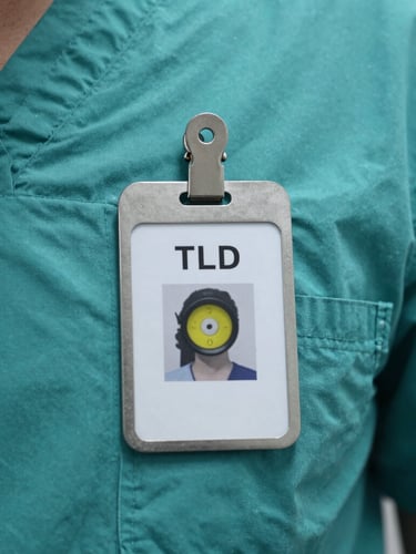 Macro shot of a personal TLD dosimeter badge clipped to a clean teal clinical scrub uniform, sterile laboratory lighting.
