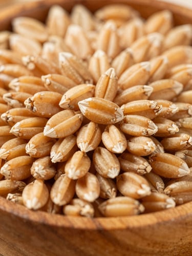 Macro shot of golden raw wheat grains in a rustic wooden bowl, warm natural daylight, high detail, 35mm