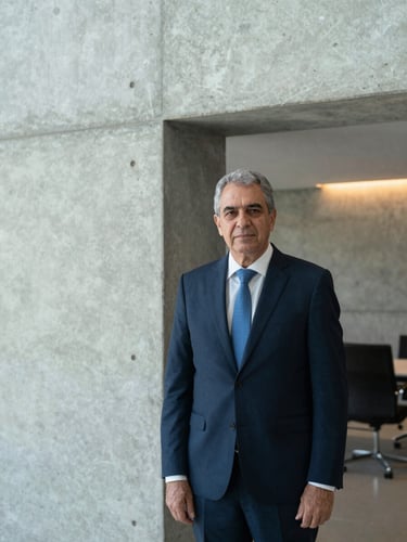 Professional portrait of Dr. Irineu Albernaz, a senior Brazilian lawyer, in a modern architectural office with concrete walls and subtle warm lighting, editorial corporate photography, 50mm lens