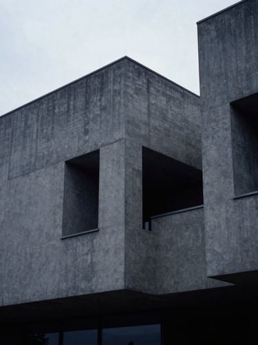 Abstract architectural geometry of a modern concrete building, cool diffused overcast daylight, desaturated slate tones, sharp focus, 35mm