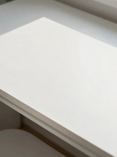 Bright high-key photography of a sunlit modern drafting table in Decatur, architectural lines, natural studio light, crisp white background, 35mm