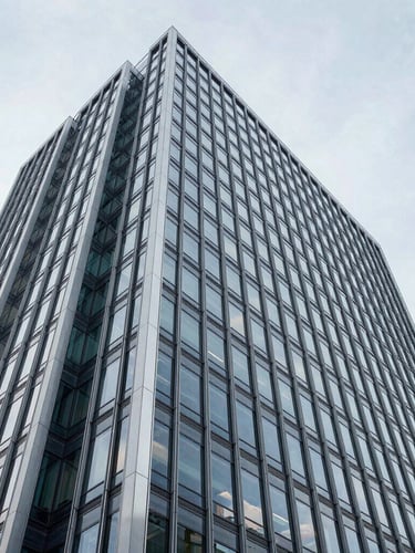 Wide architectural angle of a modern minimalist corporate skyscraper facade in Wilmington, clean steel and glass lines against a bright neutral daylight sky, cool tones, high clarity.