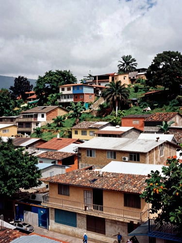 Documentary film photography of community resistance in an urban Colombian neighborhood, high contrast, natural overcast light, rich earthy tones, 35mm lens.