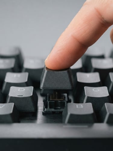 Crisp macro shot of a modern mechanical keyboard keycap being pressed, bright clean studio lighting, neutral gray background, sharp focus