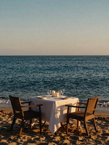 Cinematic editorial travel photography, golden hour warm light. A secluded private beach table set for two with candles, overlooking a calm deep blue ocean, 35mm film aesthetic.