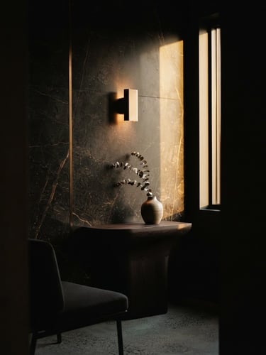 Close-up of a luxury minimalist clinic interior, dark marble wall with a subtle bronze vein, warm golden-hour window light casting long shadows, low-key editorial photography, 35mm