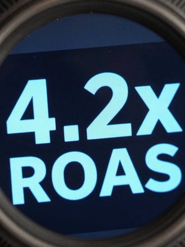 Macro view of an active performance marketing dashboard showing 4.2x ROAS in sharp light blue typography against a dark UI, metallic rim lighting.