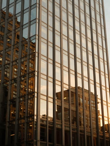 Architectural close-up of a modern glass skyscraper in Manhattan reflecting golden hour sunlight, sharp clean lines, luxury real estate aesthetic, shallow depth of field, 35mm