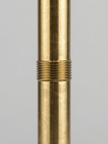 Macro close-up of a brushed brass floor lamp joint, showing precision threading and seamless metallic finish, clean industrial lighting