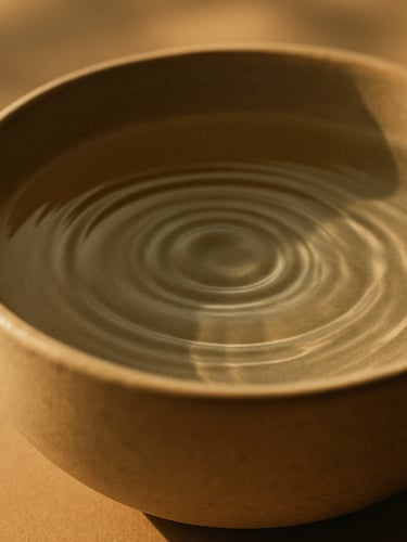 Close-up of clean water ripples in a ceramic bowl, soft morning light, earth tones, minimalist composition, 35mm photography