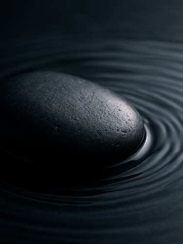 Close-up of smooth dark basalt stone with water ripples, side lighting, minimalist composition, quiet luxury texture.