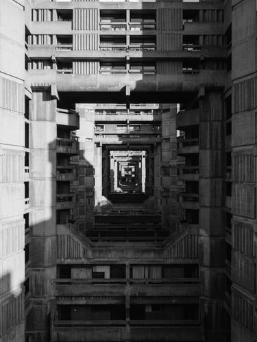 Monochromatic shot of a brutalist concrete facade, strong shadows from low-angle morning sun, precise one-point perspective, empty of people, medium format.