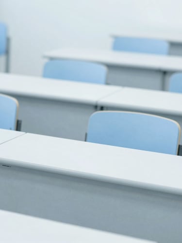 Medium close-up of a modern clinical lecture hall, bright cool daylight, sterile blue and white tones, sharp focus, professional editorial.