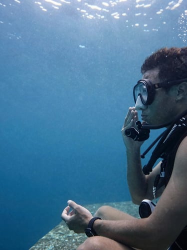 Close-up of a diver in a quiet meditative moment on a coastal ledge, soft overcast daylight, focus on controlled breathing, 35mm film photography