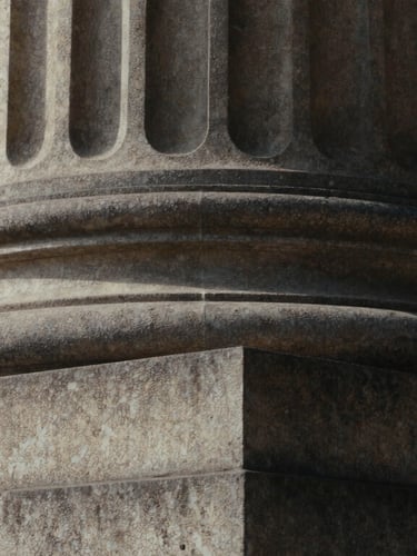 Extreme close-up of a classical stone column, deep shadows, soft overcast daylight, editorial architectural photography, 35mm film.