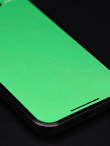Close-up macro shot of a physical phone screen displaying a vibrant Material You color-matched interface, angled perspective, neon green backlighting, dark background