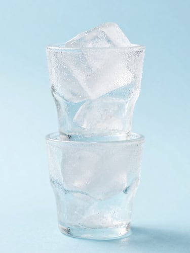 Crisp product photography of frost-dusted ice cups stacked on a minimalist light-blue backdrop, bright high-key studio light, macro ice detail, 50mm