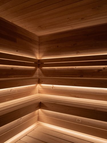 Low-angle architectural shot of a custom sauna interior, highlighting the tight wood joinery of floating cedar benches and soft, concealed LED lighting