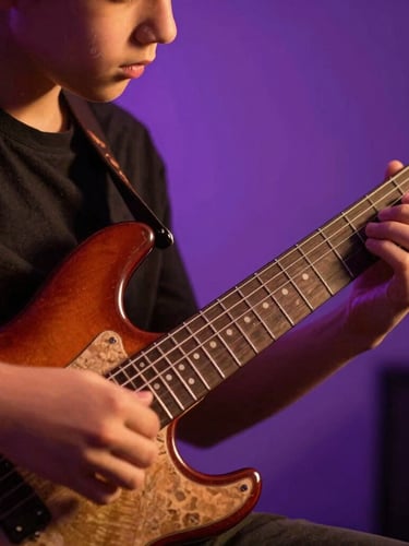 Close-up of hands guiding a young student's fingers on electric guitar frets, warm dramatic studio lighting, purple backlights, shallow depth of field