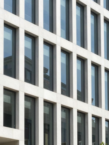Crisp architectural photography of a modern corporate office building exterior with clean geometric lines, bright natural daylight, 35mm