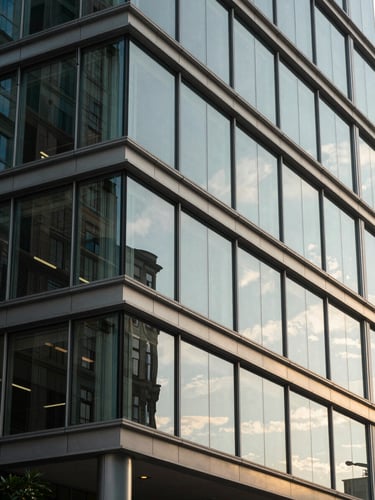 Close-up of modern architectural glass and steel office structure in Charleston, soft morning light reflecting off clean metallic lines