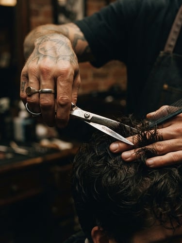 Moody editorial photography, close-up of master barber hands using steel shears on dark hair, warm low-key directional light, shallow depth of field, 35mm