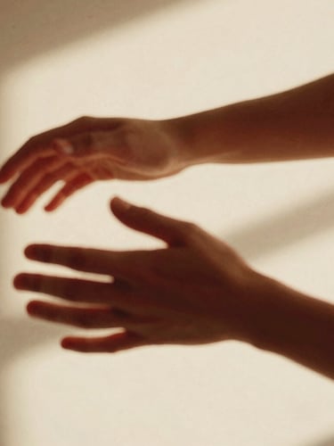 Close-up of hands and arms in motion with intentional motion blur, warm studio lighting, soft shadows, 35mm film grain, cream and cherry red tones