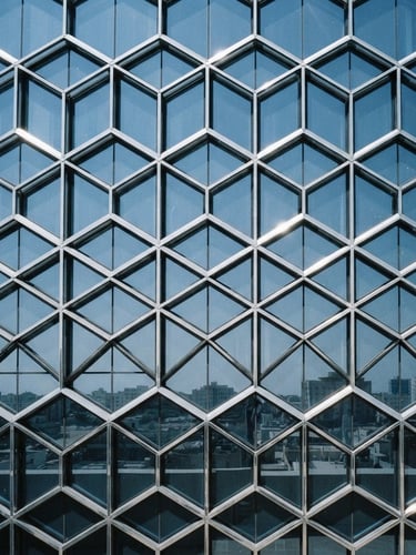 Architectural photography of a modern building facade in Jeddah, sharp metallic reflections, crisp glass-blue tones, bright harsh desert daylight, 35mm