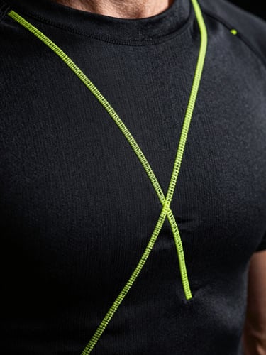 Extreme macro close-up of a high-performance sportswear garment, sharp neon volt flatlock stitching on technical matte black compression fabric, dramatic studio rim lighting, shallow depth of field