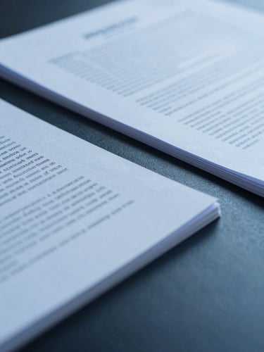 Crisp corporate photography, macro shot of professional documents being reviewed under cool diffused lighting, deep blue and slate tones, structured composition.