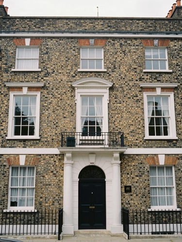 Straight-on architectural elevation of a classic British Edwardian brick townhouse, overcast daylight, sharp focus, desaturated neutral tones, 35mm