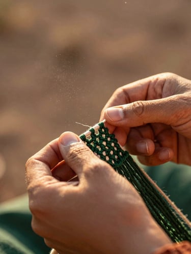 Hands of an artisan weaving intricate macramé threads under warm golden-hour sunlight, dust particles in the air, shallow depth of field, 35mm