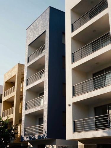 Architectural close-up of modern residential structures in Ciudad Juárez under a bright northern Mexico sky, sharp shadows, high-contrast daylight, editorial 35mm