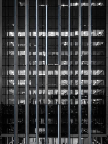Sleek architectural photography of commercial building facade with integrated smart LED lighting, cool high-key studio lighting, monochrome with subtle blue LED accents, sharp focus, 35mm