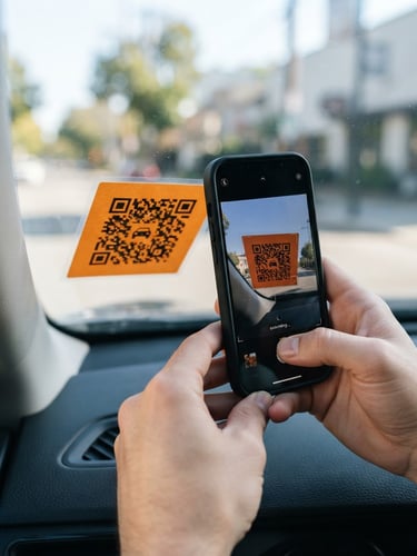 Hands holding a smartphone scanning a safety-orange QR sticker on a car windshield, bright daylight, 35mm lens, sharp focus