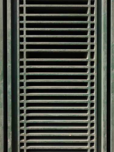 Tall narrow column of concentric rectangles aligned vertically, muted green outlines on dark field, hard geometric precision, decorative structural element