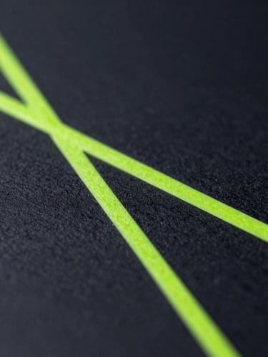 Macro close-up of physical ink-in-water mixing with sharp geometric neon-green lines, high-contrast cool studio lighting, deep charcoal background.